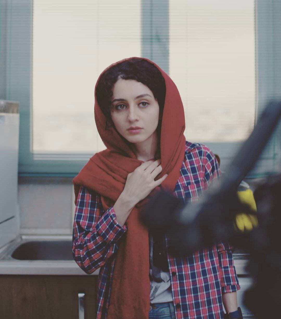 Aida in a red headscarf in a film still
